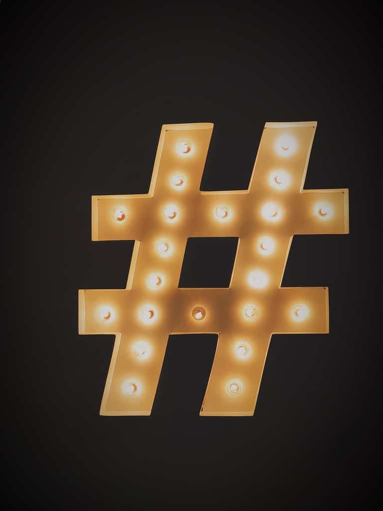 Hashtag symbol surrounded by tips for using hashtags effectively to increase social media engagement.